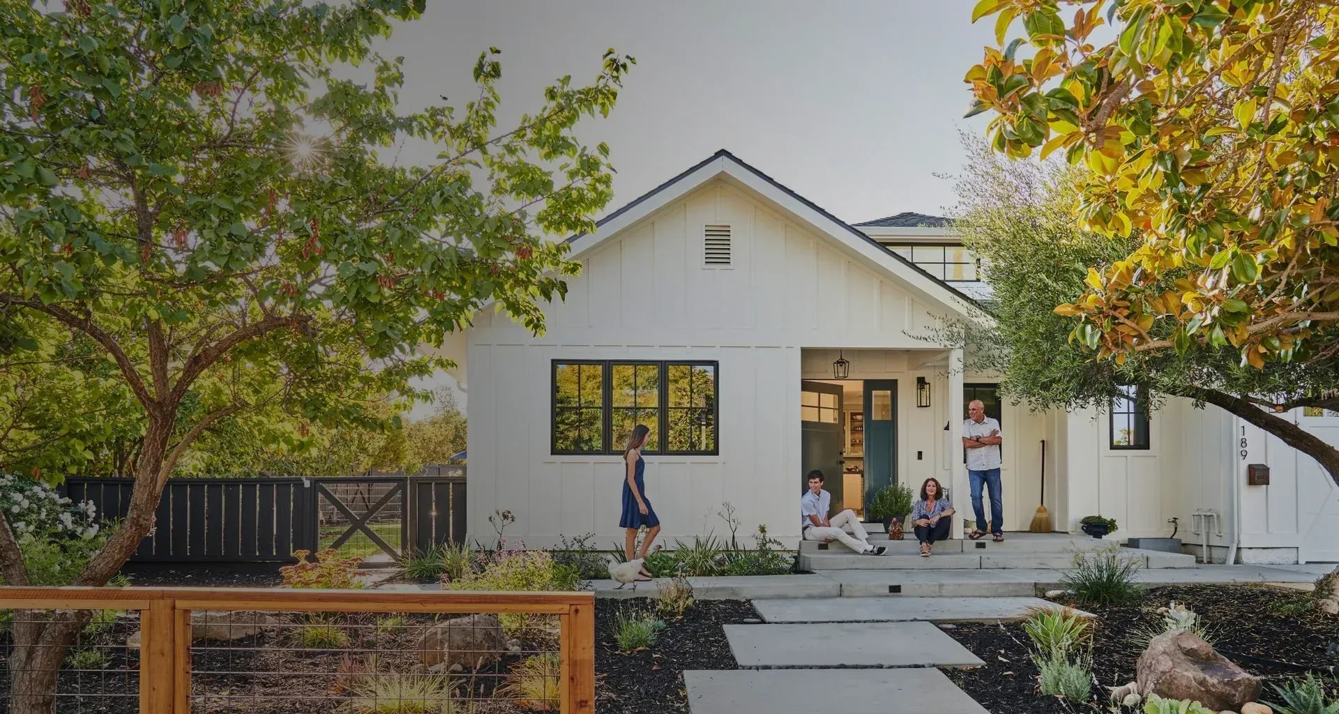 Happy family sitting on the front porch of their new home after a professional move with Marco's local and long-distance relocation services.